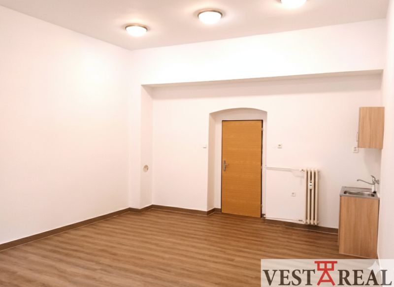 Büros mit Holzboden, weißen Wänden und einem Waschbecken.