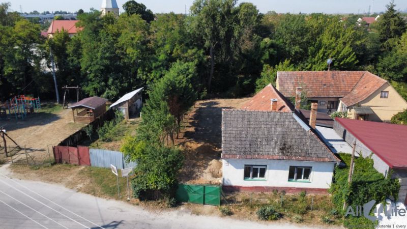 Ein Einfamilienhaus am Platz des hl. Florian, Krakovany, umgeben von Grünflächen und einem Kinderspielplatz.