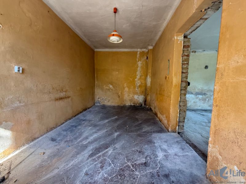 Ein Zimmer in einem Einfamilienhaus mit Betonboden und orangefarbenen Wänden.