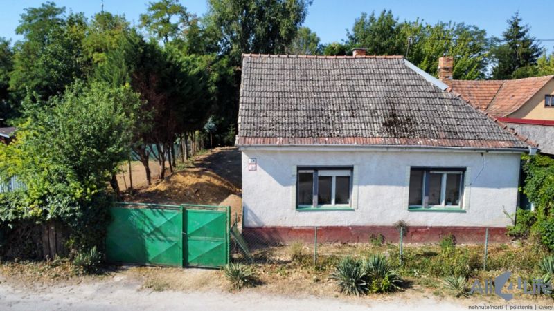 Ein Einfamilienhaus am Platz des hl. Florian in Krakovany, umgeben von Grün und einem Zaun.