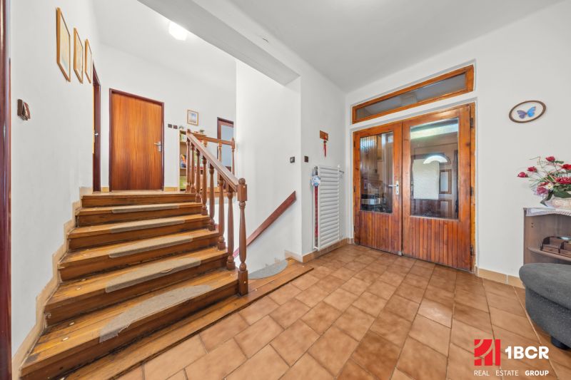 Innenraum eines Einfamilienhauses mit Treppe, Fliesen und Wanddekorationen.