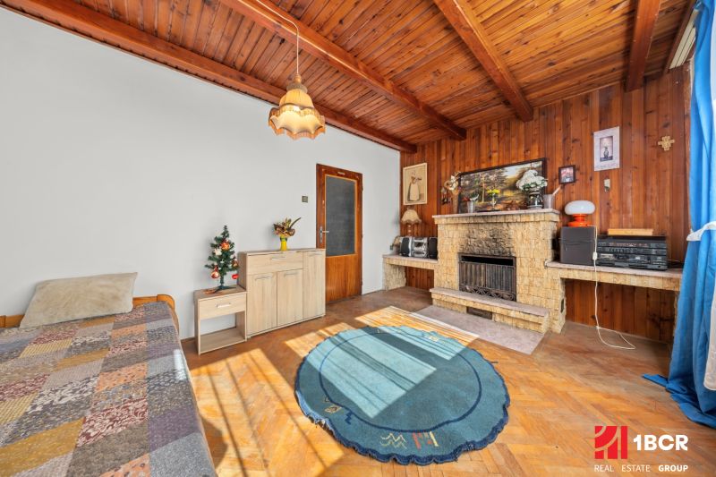 Innenraum eines Einfamilienhauses mit Kamin, Holzboden und Teppich.