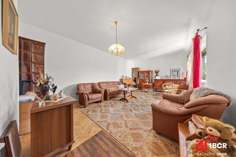 Wohnzimmer in einem Einfamilienhaus mit Holzboden, bequeme Ledersofas.