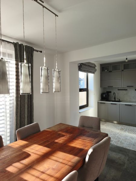 Esstisch mit Holzdekor und graue Schränke in einem Einfamilienhaus.