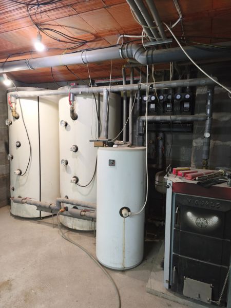 Technische Anlage in einem Einfamilienhaus mit Boiler und Kessel, Rohrleitungen durch den Raum.