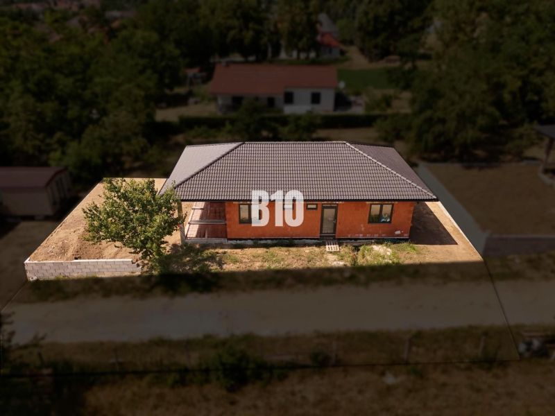 Ein Einfamilienhaus in Čeľadice mit einer Ziegelfassade, einem Schrägdach und einer Umzäunung.