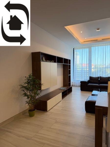 Wohnzimmer in einer 3-Zimmer-Wohnung mit Holzboden, Sofa und Möbelwand.