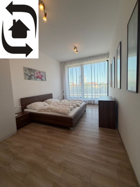 Schlafzimmer in einer 3-Zimmer-Wohnung mit Holzboden und großem Fenster.