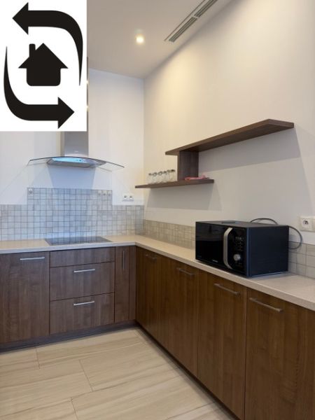 Küche in einer 3-Zimmer-Wohnung mit Holzdekor und eingebauten Geräten.