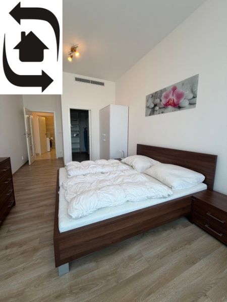 Schlafzimmer mit Holzboden und Bett in einer 3-Zimmer-Wohnung.