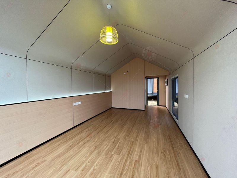 Innenraum einer Hütte mit Holzboden und einer auffälligen Hängelampe.