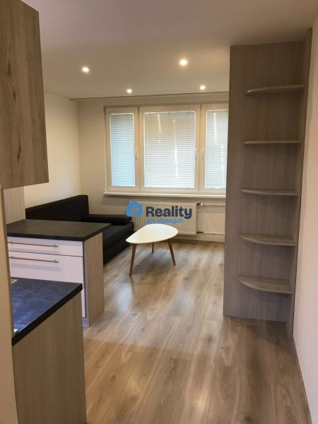 Garçonniere mit Sofa, Tisch und Holzboden.