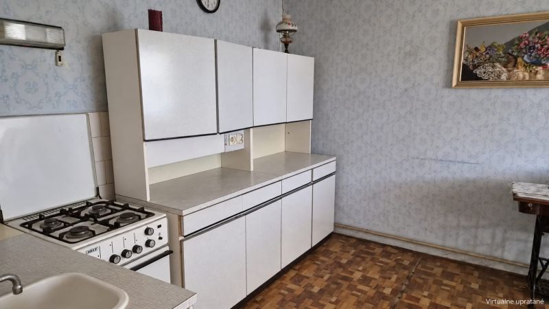Eine Küche in einem Einfamilienhaus mit einem Gasherd und einem Boden in Holzoptik.