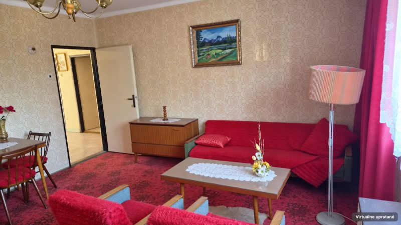 Wohnzimmer in einem Einfamilienhaus mit rotem Teppich und Retro-Möbeln.