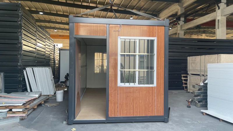 Containerhaus mit Holzboden im Inneren der Halle.