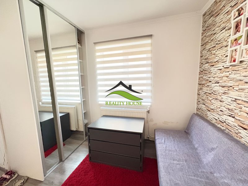 Innenraum eines Einfamilienhauses mit Sofa, Spiegelschrank und dekorativer Wand.