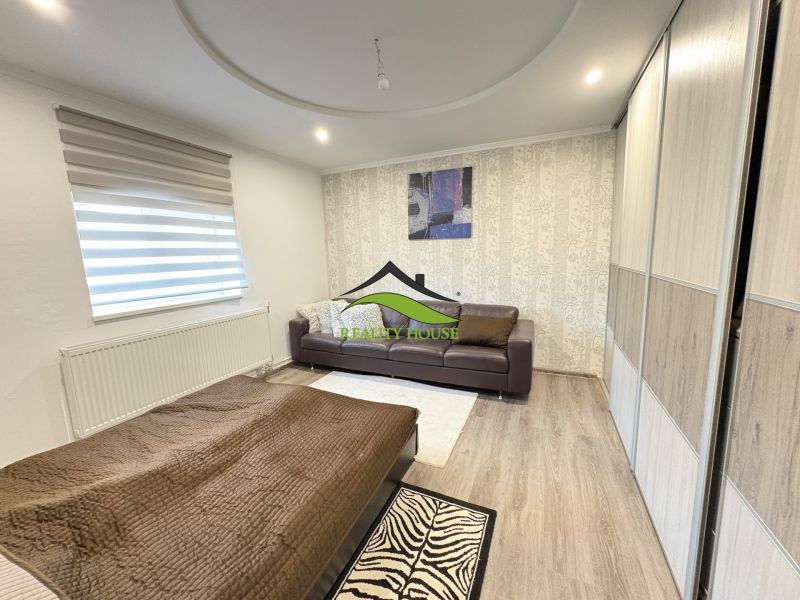 Wohnzimmer in einem Einfamilienhaus mit Holzboden und Sofa.
