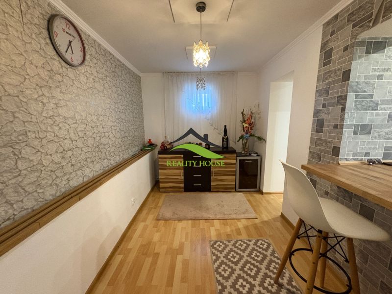 Innenraum eines Einfamilienhauses mit einer Wand in Steindekor und einem Boden in Holzdekor.