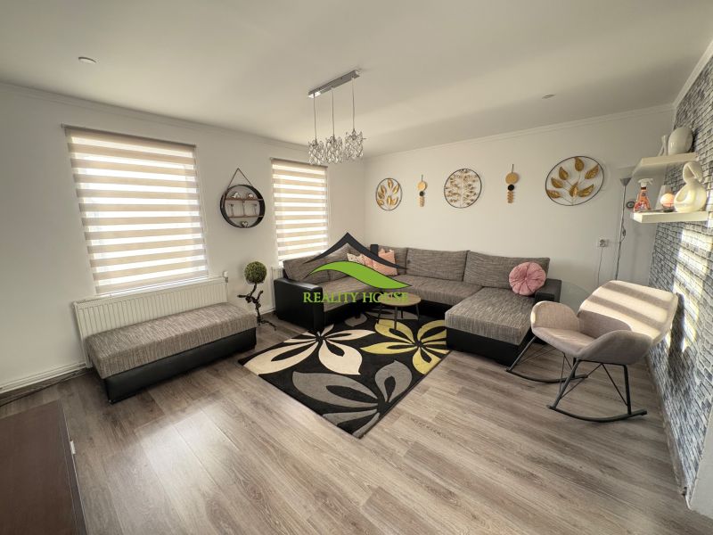 Wohnzimmer eines Einfamilienhauses mit Wand- und Bodendekor in Holzoptik.