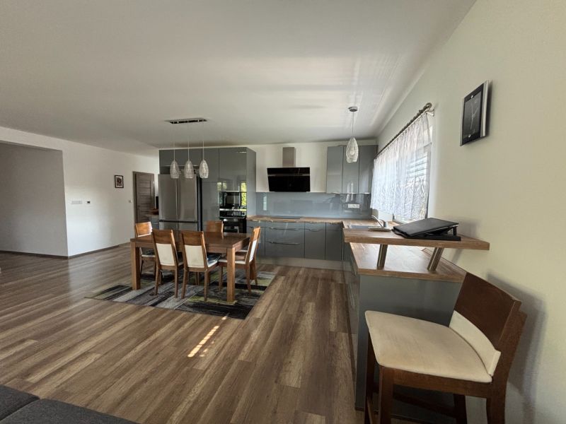 Küche in einem Einfamilienhaus mit Holzboden und Esstisch.