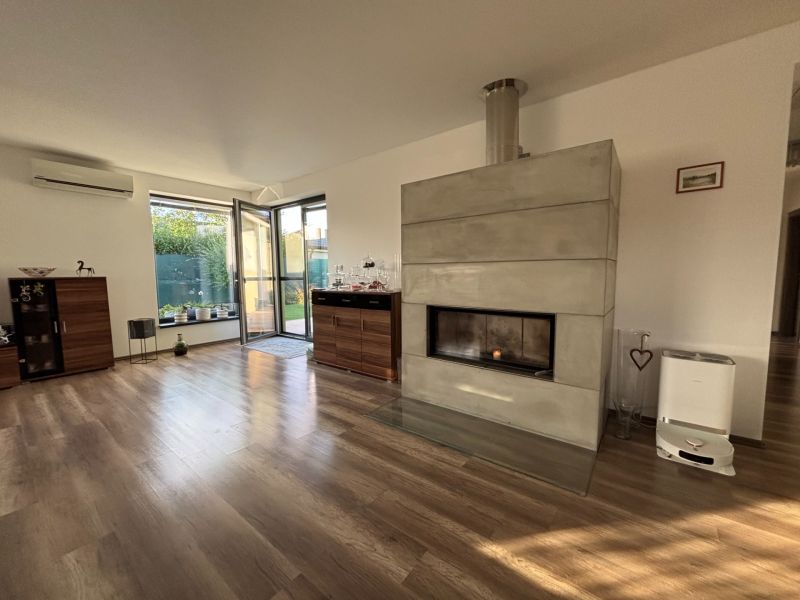 Wohnzimmer in einem Einfamilienhaus mit Kamin und Holzboden.
