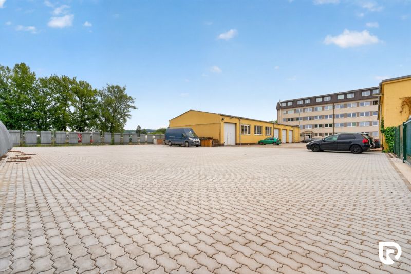 Parkplatz und gelbes Gebäude in der Brnianska Straße in Trenčín, geeignet für Büros.