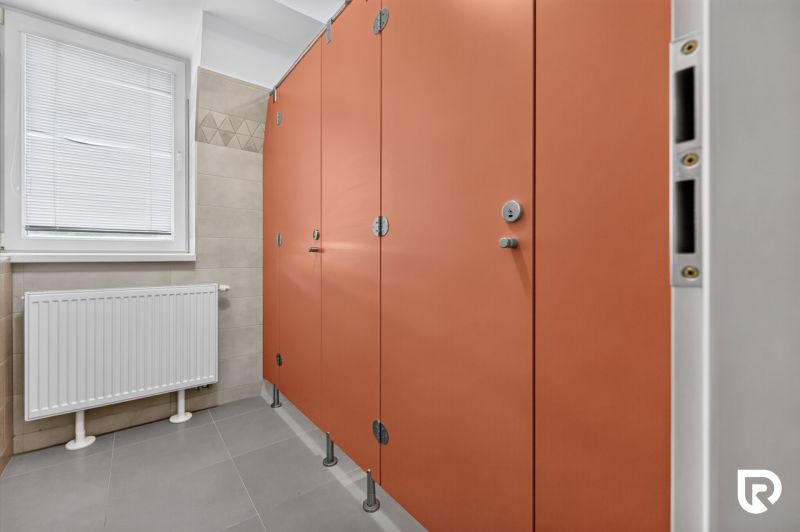 Orangene Kabinen mit Türen in öffentlichen Toiletten in Büros.