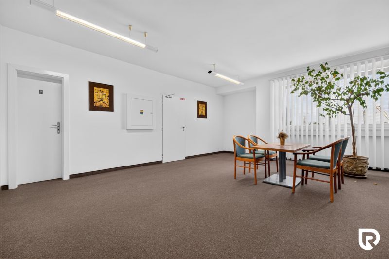 Büros mit Tisch und Stühlen, Teppich, Zimmerpflanze, dekorative Bilder.