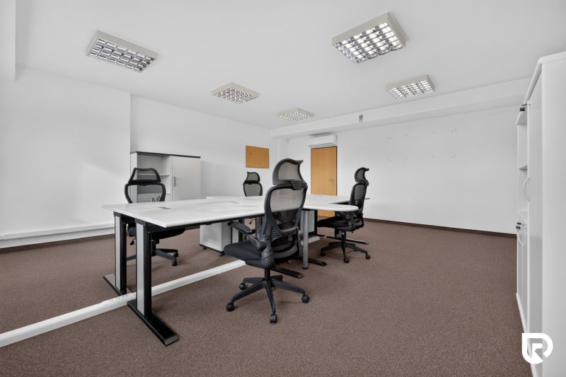 Büros mit Konferenztisch, ergonomischen Stühlen und Aufbewahrungsschränken.