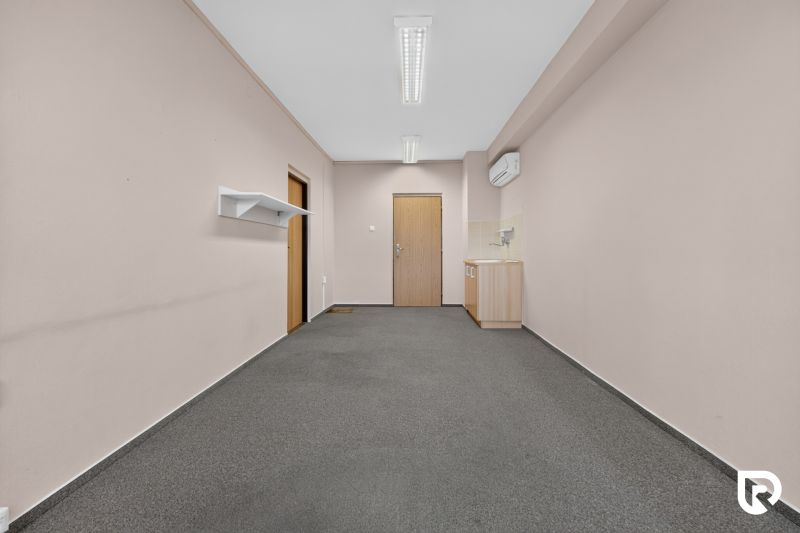 Büros mit Teppichboden und kleiner Küche, ein einfacher Raum für Arbeit oder Treffen.