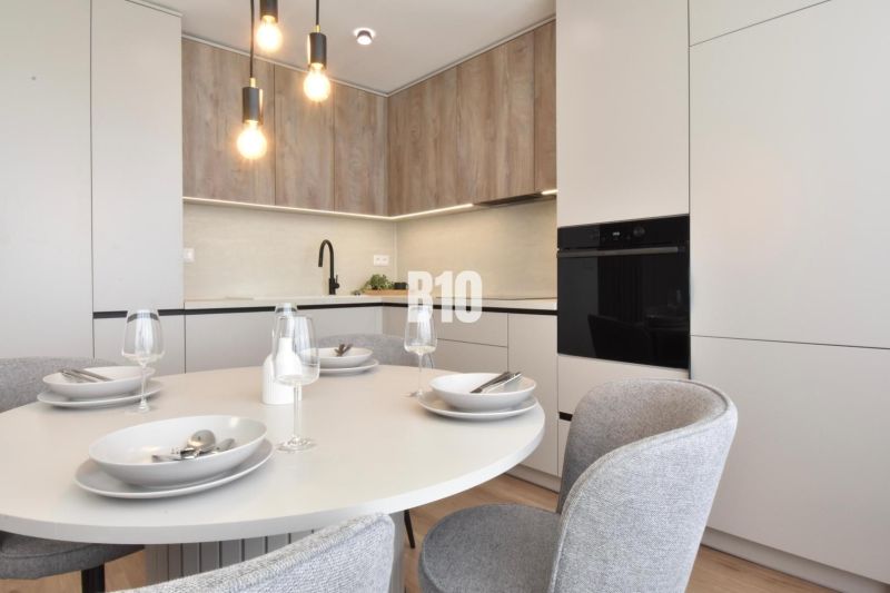 Esszimmer in einer 4-Zimmer-Wohnung mit rundem Tisch und Boden mit Holzdekor.