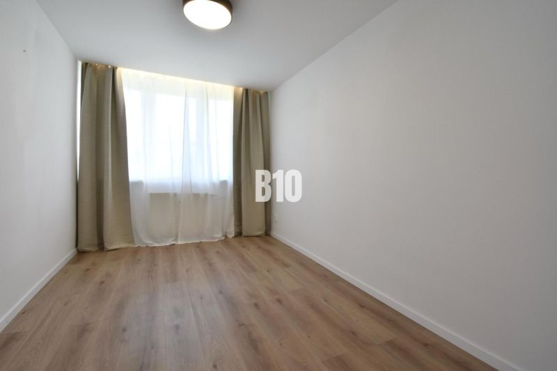 Ein Zimmer mit Vorhängen und einem Boden in Holzoptik in einer 4-Zimmer-Wohnung.