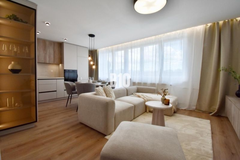 Wohnzimmer mit heller Couch, Essbereich und Küche in einer 4-Zimmer-Wohnung.