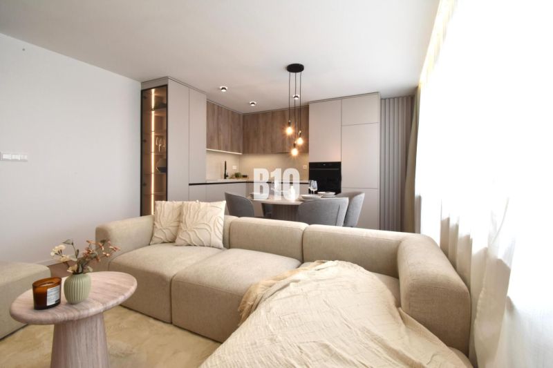 Wohnzimmer mit Küche in einer 4-Zimmer-Wohnung mit Holzboden.