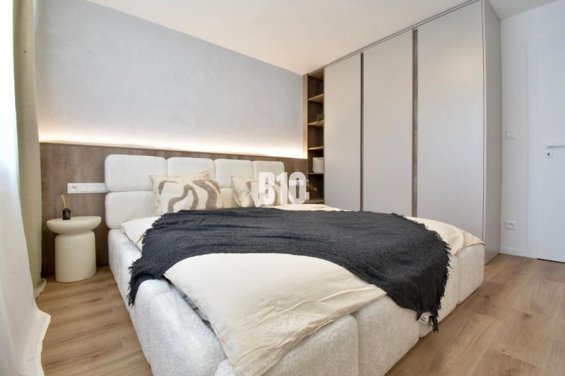 Schlafzimmer in einer 4-Zimmer-Wohnung mit Bett, Einbauschrank und Bodenbelag in Holzoptik.