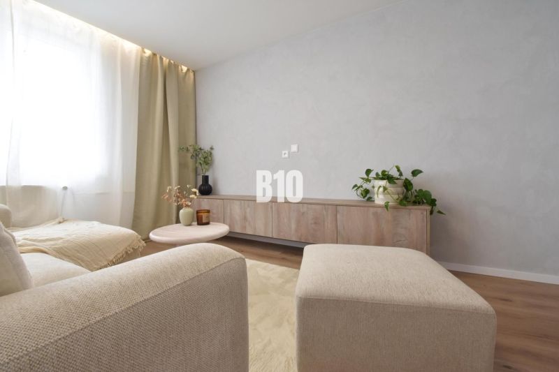 Helles Wohnzimmer in einer 4-Zimmer-Wohnung mit Holzboden und minimalistischen Möbeln.