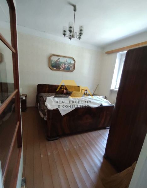Schlafzimmer in einem Einfamilienhaus mit Holzboden und einem Bild an der Wand.