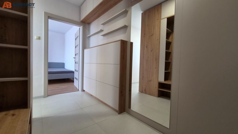 Innenraum mit Holzboden und Spiegel in einer Einzimmerwohnung.