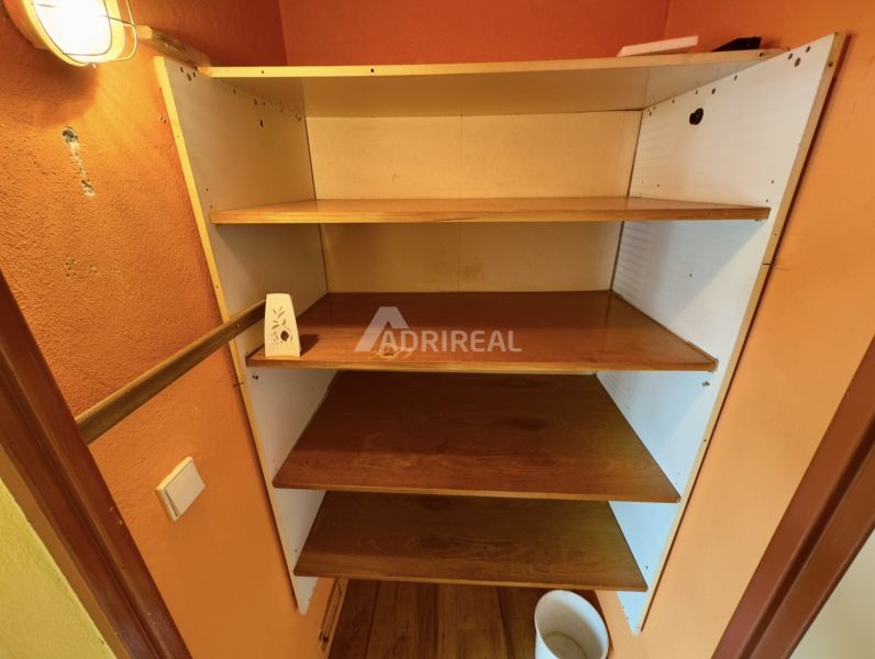 Ein Regal mit vier Holzböden in einer Einzimmerwohnung, Boden mit Holzdekor.