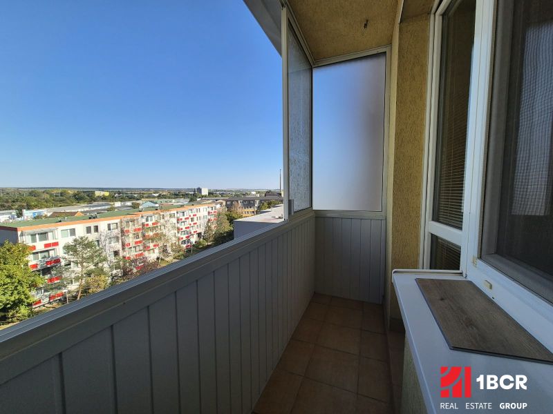 Der Balkon eines Einzimmerapartments mit Blick auf die Bystrická-Straße in Pezinok, sonniger Tag.
