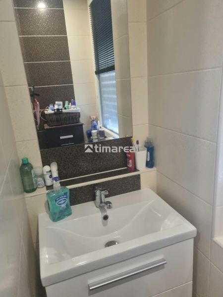 Badezimmer in einer 3-Zimmer-Wohnung mit stilvollem Waschbecken und Regalen für Zubehör.