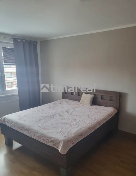 Schlafzimmer in einer 3-Zimmer-Wohnung mit einem Bett und einem Boden in Holzoptik.