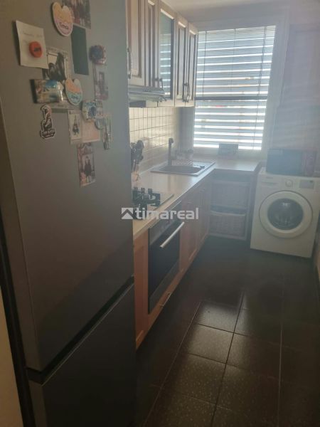 Küche in einer 3-Zimmer-Wohnung mit Kühlschrank, Herd und Waschmaschine.
