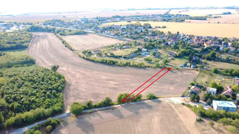 Landwirtschaftliche und forstwirtschaftliche Flächen in Podhájska, umliegende Felder und entfernte Gebäude.