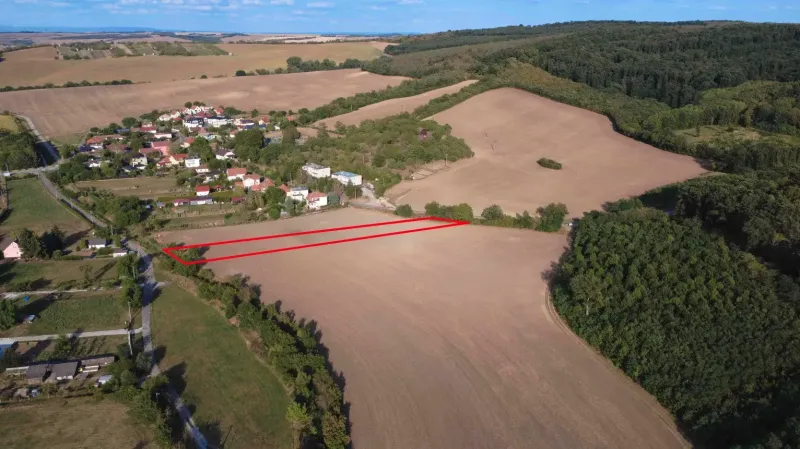 Luftaufnahme von landwirtschaftlichen und forstwirtschaftlichen Flächen bei Podhájska, umgeben von Dorf und Wald.