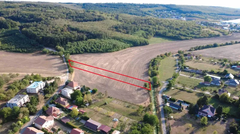 Luftaufnahme von landwirtschaftlichen und forstwirtschaftlichen Flächen in Podhájska, umgeben von Häusern und Straßen.