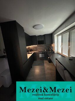 Moderne Küche in einer 2-Zimmer-Wohnung mit elegantem Design und großen Fenstern.