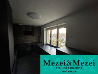 Küche in einer 2-Zimmer-Wohnung mit dunklen Möbeln und Blick aus dem Fenster.