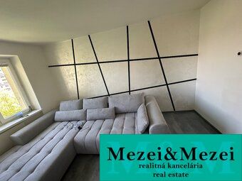 Innenraum einer 2-Zimmer-Wohnung mit einem bequemen Sofa und einem Boden in Holzoptik.