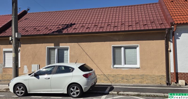 Ein Einfamilienhaus in Trnava mit einem roten Dach und einem weißen Auto, das vor dem Haus geparkt ist.